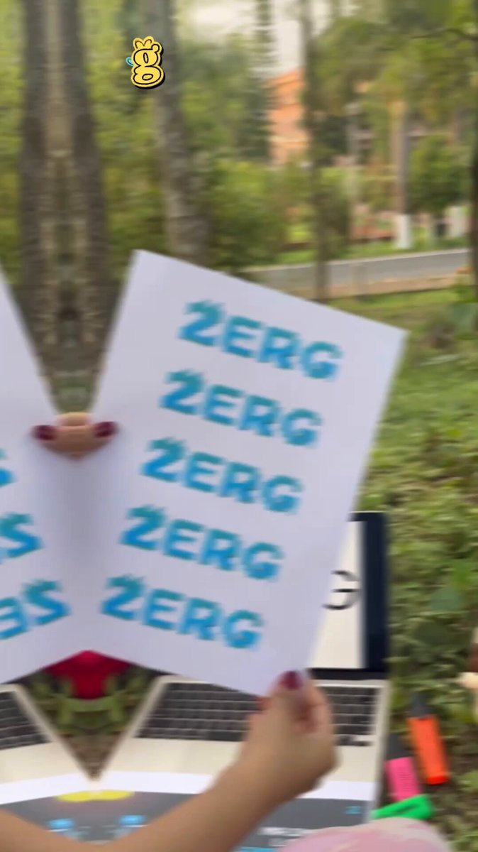 The image features a person holding up a sign with the word "ZERG" written on it. The sign has been edited to say "14 days since ZERG Mainnet launched and damn... what a ride it has been". This alteration suggests that the person is expressing their dissatisfaction or disappointment about the slow progress of the project, possibly due to its launch date being delayed by 14 days.

In addition to the sign, there are also some objects in the image such as a laptop computer and a keyboard. The presence of these items might indicate that the person is involved in some form of digital work or activity related to the project.
