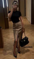 A woman poses for a mirror selfie in a black fitted top and beige leather pencil skirt with a front slit, holding a small black handbag, ready for a night out. A watermark reading "@mariakradoil" is visible in the corner, matching the post's celebratory "GM GM" Friday vibes.