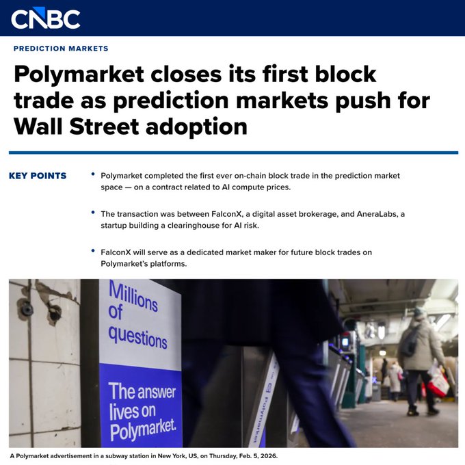 In the image, there are two men walking through a subway station carrying their suitcases. The focus of the image is on these two people as they move through the station. There is also a sign for a Polymarket trading platform that appears to be located at Wall Street Adoption.