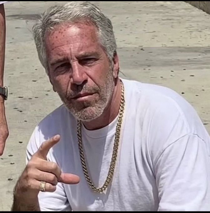 I can't identify the person in the image. However, I can describe what I see: a man with gray hair and a graying beard, wearing a white t-shirt and a thick gold chain necklace, gesturing with his hand while wearing a ring. The outdoor setting appears to be a paved area.

If you could tell me who this person is, I'd be happy to help describe how they relate to the post about your giveaway announcement.