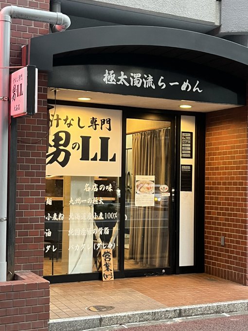 Exterior of a Japanese ramen shop named 'Men no LL' (男のLL), featuring a black awning reading '極太濁流らーめん' and signage about Kyushu-style tonkotsu ramen.