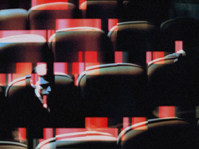 A glitchy, fragmented image of a man's face overlaid on rows of red theater seats, with heavy distortion and color separation effects.