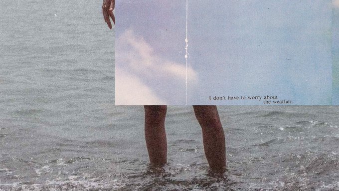 An artistic photograph showing a person's legs in the ocean, partially obscured by an open book or journal with a sky illustration and the text 'I don't have to worry about the weather.'