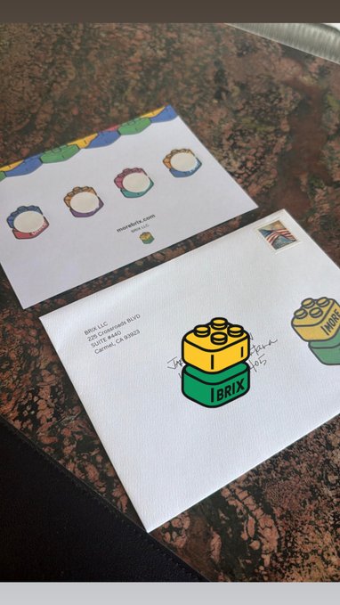 Two envelopes on a granite countertop, the top one addressed to a recipient in Costa Mesa, CA featuring 'IBRIX' LEGO brick logos with signatures and a UK postage stamp, with moneyfitta.com envelopes visible underneath.