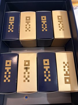 A collection of decorative boxes in navy blue and cream colors with pixelated geometric patterns, arranged in a display case.