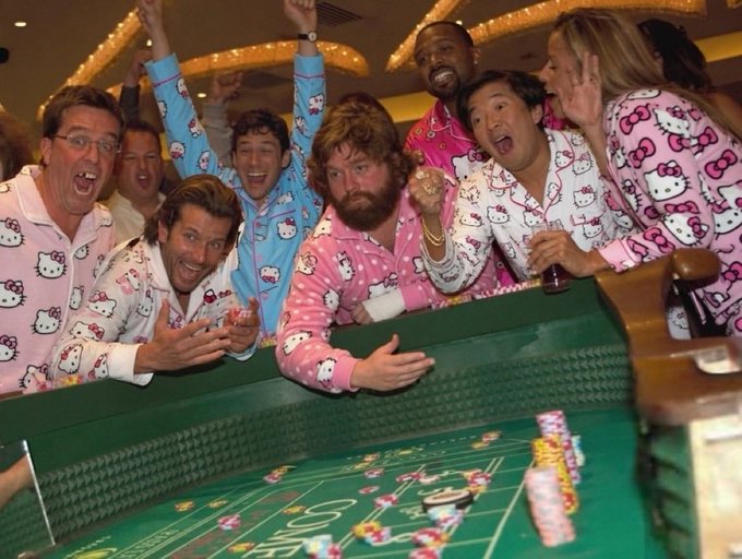 The famous 'Hangover' cast photo featuring Bradley Cooper, Zach Galifianakis, Ken Jeong, and others in Hello Kitty pajamas celebrating at a craps table.