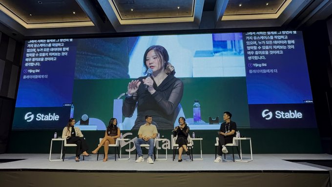 A panel discussion on the "Stable Stage" at KBW2026 titled "The Data Race Behind the AI Boom," featuring five speakers seated in front of a large screen displaying CMO Yijing Shi of GoKiteAI speaking into a microphone, alongside panelist names including Catherine Daly of Space and Time and Andrea Muttoni of Data Foundation.