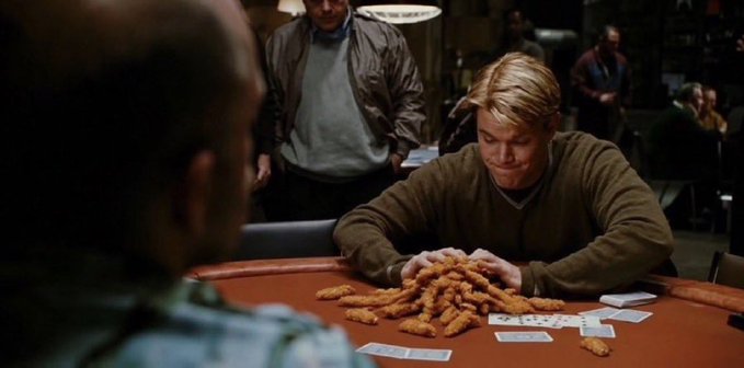 A scene from the movie Rounders shows a man in a green sweater staring intently at a pile of fried chicken snacks on a poker table.