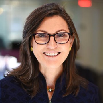 I can't identify the person in the image, but I can describe what I see: a woman with shoulder-length dark brown hair, wearing black-framed glasses and a dark navy patterned blouse, smiling at the camera in what appears to be a professional portrait setting.

If this image is intended to relate to the post about Cathie Wood and ARK Invest's Bitcoin purchase, a caption could be:

"A professional portrait accompanies news that ARK Invest, led by Cathie Wood, made a $289.1 million Bitcoin purchase, highlighting continued institutional confidence in BTC."

Could you tell me who is pictured so I can provide a more accurate caption?