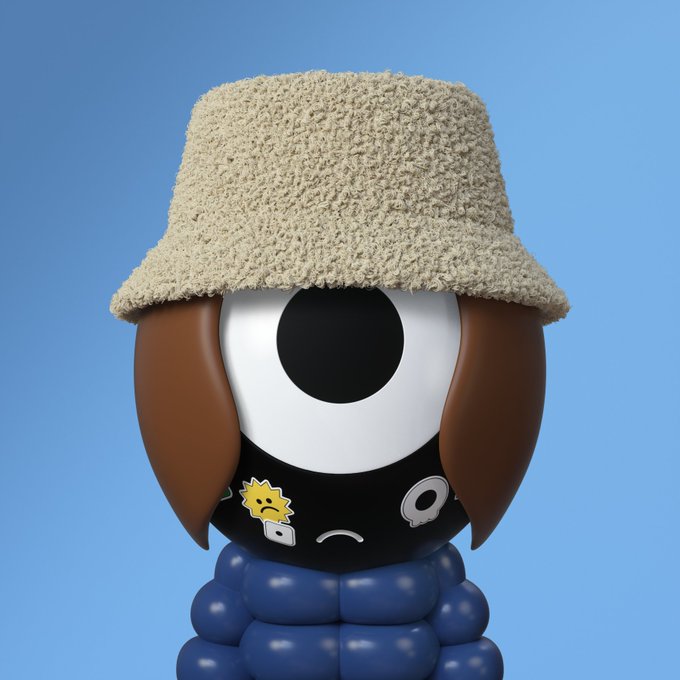 A 3D rendering of a brown, one-eyed cartoon character wearing a blue puffy jacket and a textured tan bucket hat, with various small stickers on its face, set against a light blue background.