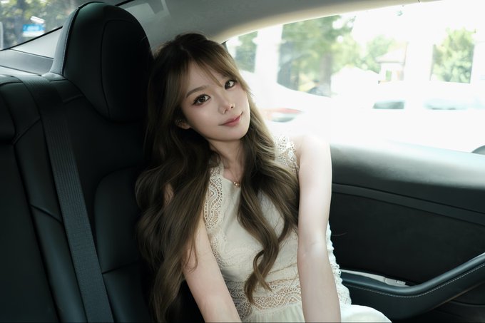 A woman with long wavy brown hair, wearing a cream lace dress, sits in the back seat of a car, smiling softly at the camera. The image conveys an elegant, fresh-start vibe that complements her post announcing her new Marketing & BD role at SmartX (@SmartXTerminal), signaling the exciting beginning of her professional journey with the company.