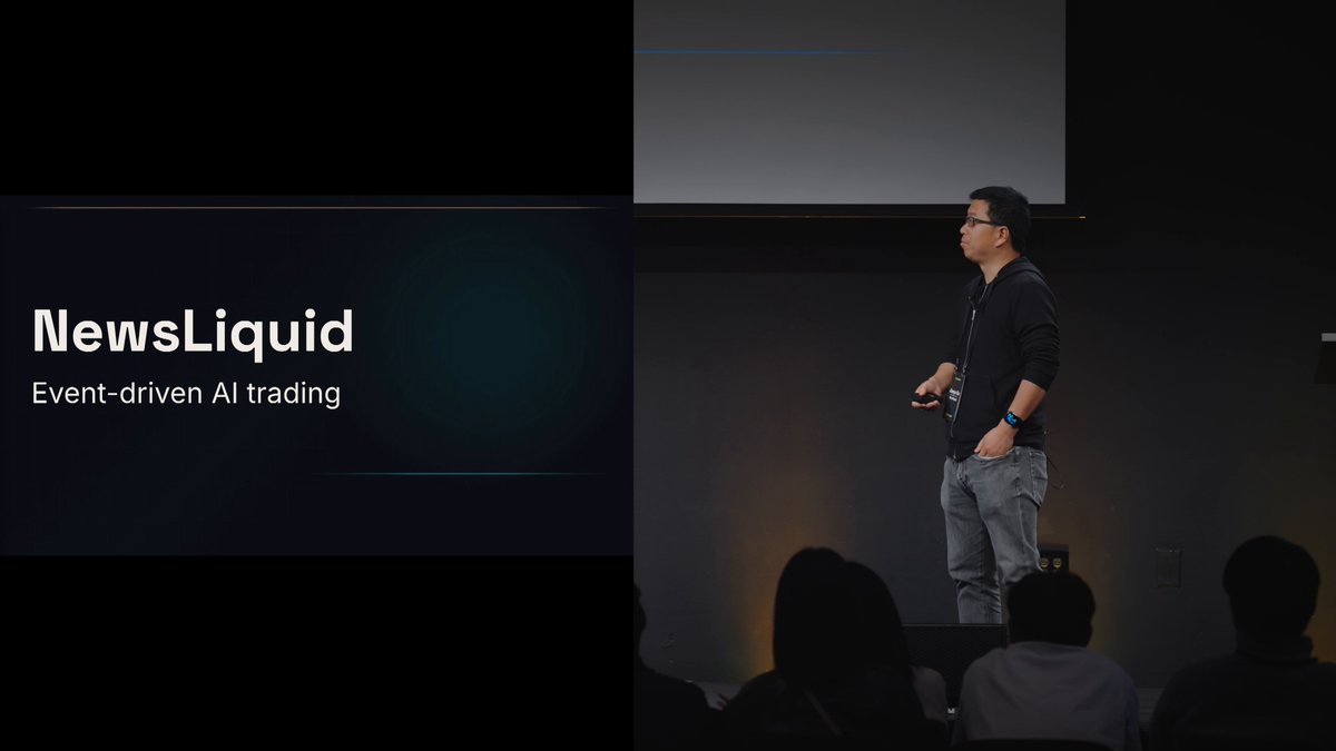 The image features a man standing at a podium, giving a presentation or speech. The background of the image shows a large screen displaying the text "BN也是好起来了 都能投牛子液体了 @newsliquidX @cryptoxiao". This suggests that the man is speaking at an event or gathering, possibly related to cryptocurrency or financial news. The image also includes a caption about the post being about News Liquid and an event-driven AI trading platform.