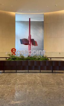 A modern office lobby features a large 'egatepoint' sign with red geometric blocks on a backlit wall behind a planter.