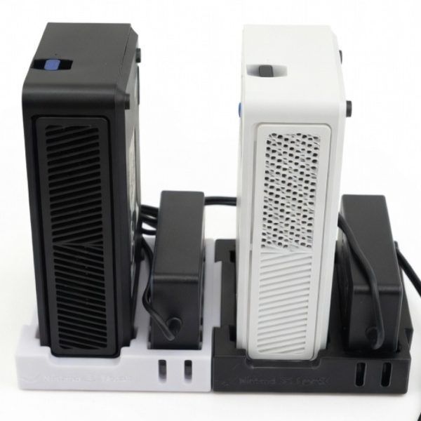 Two Avalon Nano 3S miners (one black, one white) stand vertically mounted on the branded Nano 3S Dock, which holds them upright alongside their PSUs for a cleaner desktop setup.