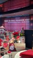 A small image showing people at what appears to be a tech or crypto event with display screens in the background.