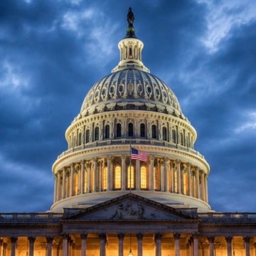 The image shows the illuminated dome of the U.S. Capitol Building at twilight, with an American flag visible against a deep blue, cloudy sky. The accompanying post ties this to the CLARITY Act, urging Coinbase and the Senate to finalize crypto market structure legislation during recess, with the Capitol symbolizing the legislative action being demanded.