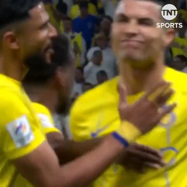A screenshot from TNT Sports showing two soccer players in yellow jerseys celebrating, with one making an emotional gesture.