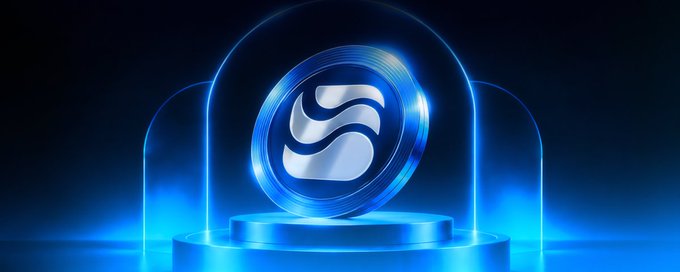 A 3D rendered image of a glowing blue and silver crypto token or coin featuring a stylized 'S' logo, displayed on a pedestal under a glass dome with blue lighting.
