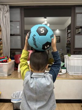 The image features a young boy holding up a soccer ball, which has the number "2002" written on it. The boy appears to be playing with the soccer ball or possibly celebrating something related to the ball's number. The photo also includes text that reads "@bitget", "@bitgetyaya", and "@GracyBitget". These texts seem to be part of a larger conversation, possibly about soccer balls or some other topic involving the boy and his soccer ball.