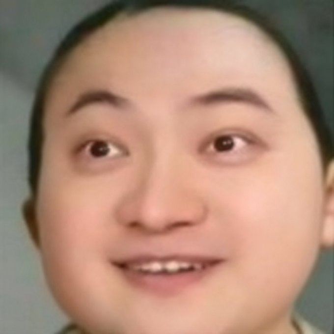 A close-up portrait photo of a smiling East Asian woman with dark hair pulled back.