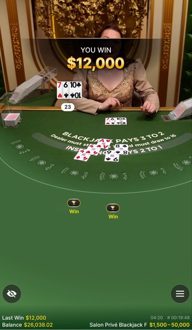 The image features a smartphone screen displaying a Blackjack game, with two players taking part in a match against each other. The woman sitting at the table appears focused as she plays the virtual card game. In addition to her position, there are various elements on the screen such as a green background, a table, and text that provides information about their winnings or losing hands.

The post suggests that this Blackjack game is an easy way for everyone to try their luck at gambling. It appears to be targeting casino goers who might want to know if they have won any money or lost some while playing the virtual game on their smartphones, possibly in a social setting such as within groups of friends or family members gathered around a table.