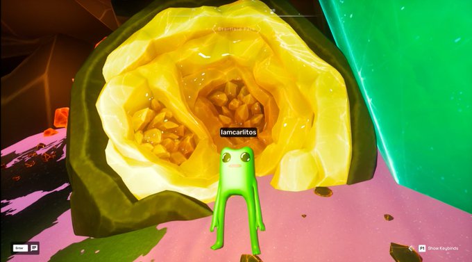 A screenshot from a video game showing a green, four-legged character named 'lamcariltos' standing in front of a large, crystalline, yellow cave structure.