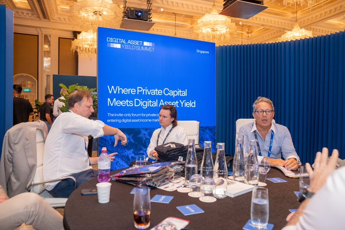 Three men seated at a roundtable discussion at the 'Digital Asset Yield Summit' Singapore, with a banner reading 'Where Private Capital Meets Digital Asset Yield.'