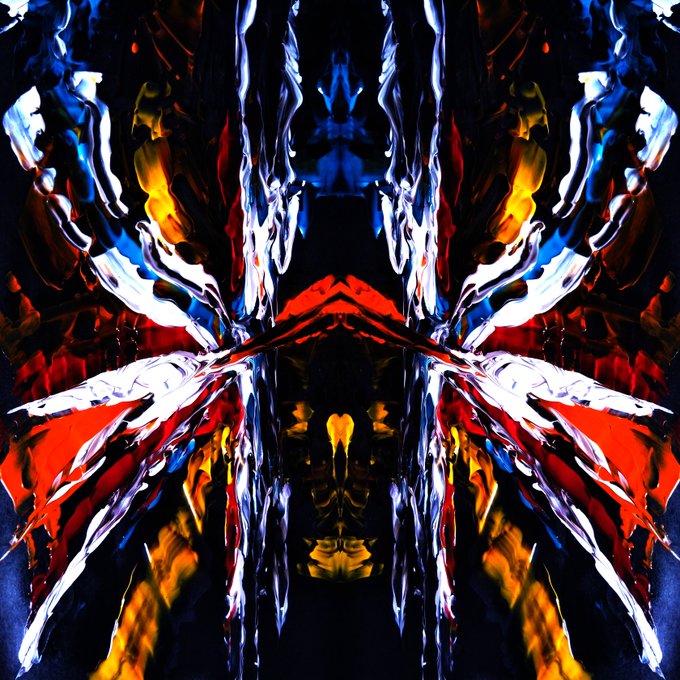 An abstract, symmetrical digital artwork with mirrored reflections in vibrant reds, blues, yellows, and whites, resembling mirrored paint strokes or flames on a dark background.