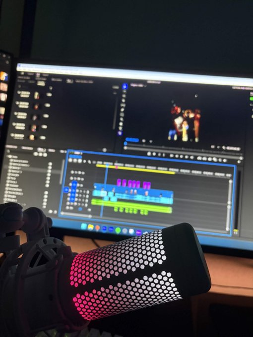 A podcast microphone sits in front of a computer screen displaying video editing software with colorful timeline tracks and a preview window. The image shows a creator in the final stages of editing a video about the "$ANSEM AIRDROP," as indicated by the accompanying caption.