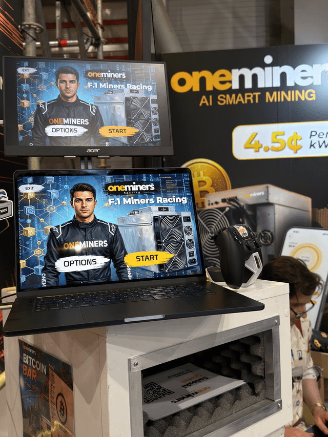 The image shows a laptop computer with two monitors, one of which displays an advertisement for Bitcoin. A person can be seen sitting next to the laptop screen. The text in the image reads "What do you think about OneMiners attending BTC Prague after Las Vegas?". This suggests that someone might be discussing or considering the idea of attending a Bitcoin event in Las Vegas with the help of the laptops and monitors, possibly for research purposes or planning an event related to cryptocurrency.

The presence of multiple screens indicates that there could be more information available about the event or the people involved. The person sitting next to the laptop might be reading articles, watching videos, or looking up details about Bitcoin events in Las Vegas.