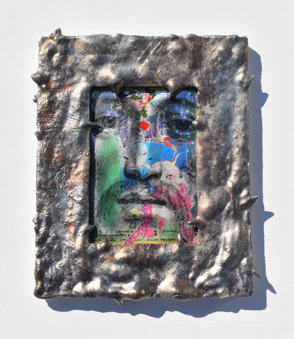 A heavily textured, silver-toned ornate frame surrounds a glitchy, colorful artwork depicting what appears to be a figure with text including "Card NFT 2" and a URL fragment, matching the post's reference to a "Card NFT 2" piece—though its rough, melted metallic border gives it an industrial, almost reliquary feel far from the classic "OG jesus card" referenced.