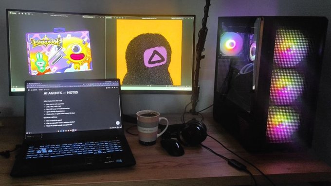 A dual-monitor gaming/work setup features a laptop showing 'AI AGENTS — NOTES' alongside monitors displaying colorful artwork, with a PC tower featuring RGB-lit fans and a coffee mug on the desk.