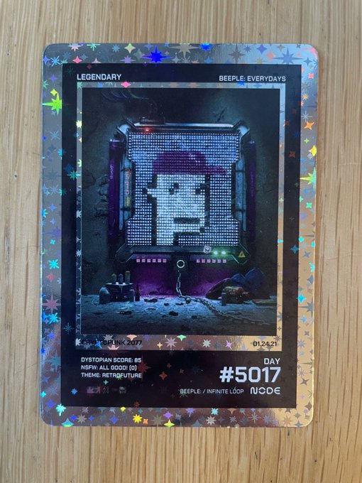 A holographic 'Beeple Everydays Legendary' trading card (#5017) dated 01.24.21 featuring a digital mosaic artwork, with Dystopian Score: 85.