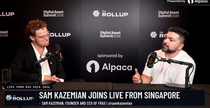 Two men are seated at a table with microphones at a media event, with the backdrop reading 'Digital Asset Summit 2026' and 'sponsored by Alpaca'. The lower banner states 'SAM KAZEMIAN JOINS LIVE FROM SINGAPORE' and identifies him as 'FOUNDER AND CEO OF FRAX'.