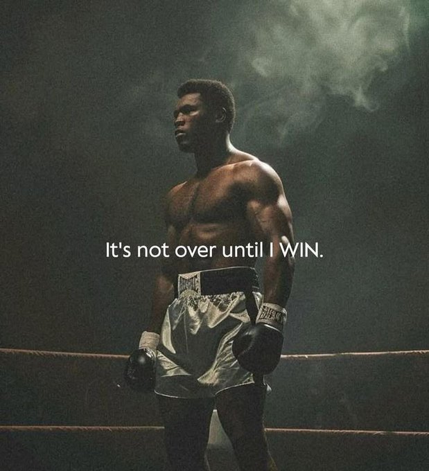 A shirtless Black boxer wearing white Everlast shorts and gloves stands in a smoky ring with the text 'It's not over until I WIN.' overlaid.