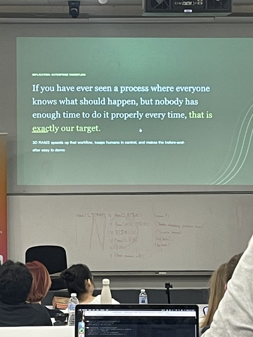 A projector screen displays a slide titled "APPLICATION ENTERPRISE WORKFLOW" stating "If you have ever seen a process where everyone knows what should happen, but nobody has enough time to do it properly every time, that is exactly our target. 3D RAMS speeds up that workflow, keeps humans in control, and makes the before-and-after easy to demo." Audience members are seated facing the presentation in what appears to be a classroom or conference setting, fitting the post's reference to a Kaspa ($KAS) talk covered by @HeavyHashMedia.