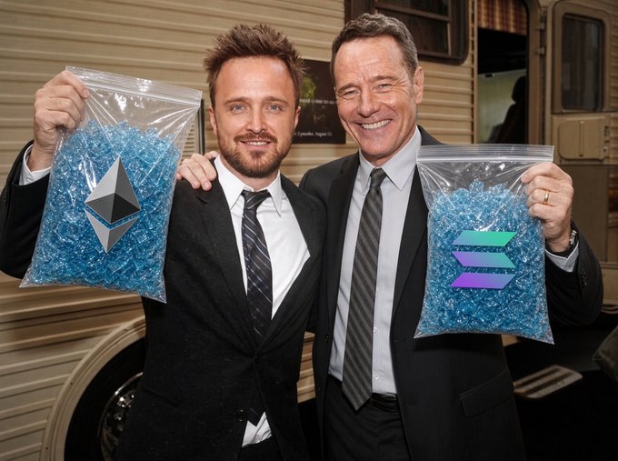 Two men in suits smiling while holding clear bags filled with blue crystals featuring the Ethereum (ETH) and Solana (SOL) logos, posed in front of an RV.