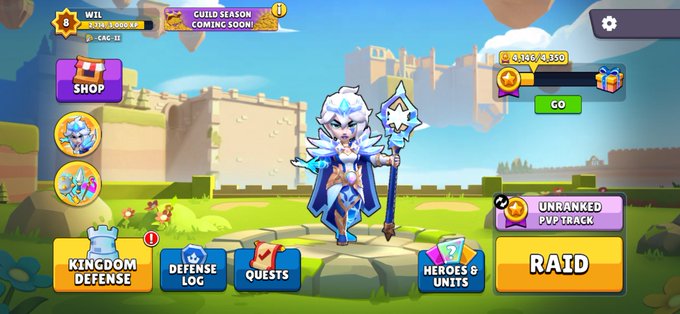 A mobile game main menu featuring an icy blue-haired wizard character in a fantasy setting, with buttons for Shop, Kingdom Defense, Defense Log, Quests, Heroes & Units, and Raid.