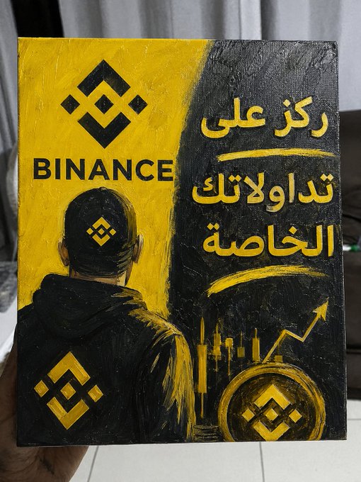 A hand holds a hand-painted canvas featuring the Binance logo and Arabic text reading "ركز على تداولك الخاصة" (Focus on your trading) alongside a hooded figure and rising candlestick chart with an upward arrow, visually reinforcing the message of staying disciplined and committed to one's own trading journey.