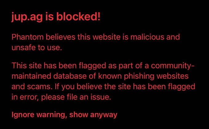 A warning screen from the Phantom wallet blocking jup.ag, stating "Phantom believes this website is malicious and unsafe to use" and that it has been flagged as a known phishing site, with an option to "Ignore warning, show anyway."

The image supports the post by showing Phantom's browser falsely flagging Jupiter Exchange's official jup.ag domain as a phishing site, prompting criticism of the "friendly fire" against a trusted crypto project.