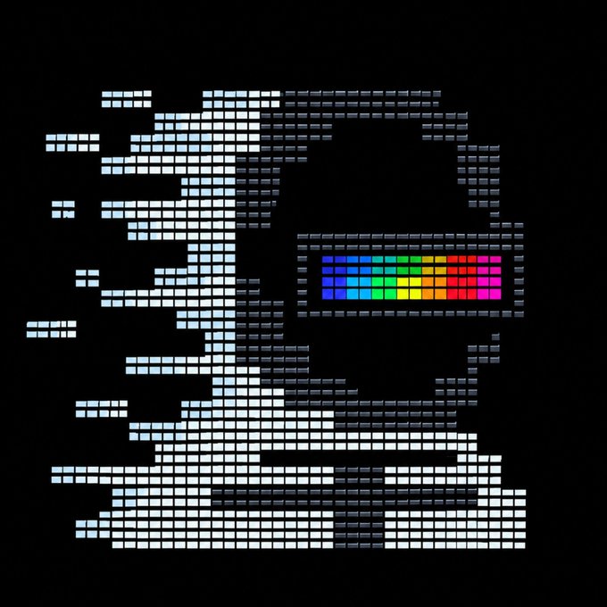 A pixelated, ASCII-style digital portrait resembling a face composed of white and grey rectangular blocks, with a vibrant rainbow-colored rectangular block where the mouth would be, set against a black background.