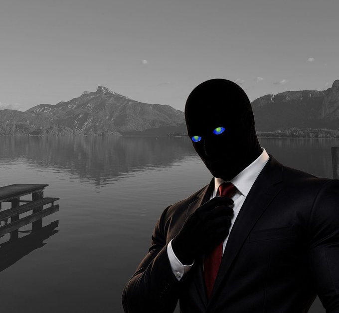 A masked figure in a black suit adjusts a red tie beside a calm mountain lake, with small rainbow-colored glowing eyes. The image appears to illustrate the accompanying crypto promotion: “$20 airdrop — just follow @Gazzonsol, drop addresses quick”; no other readable text is visible.