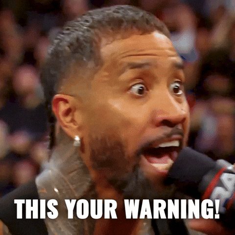 The image features a man with a shaved head holding a microphone, looking surprised or shocked while speaking into it. The caption below his speech reads "This Your Warning!". This message seems to be part of an advertisement or promotional material for some product or service.