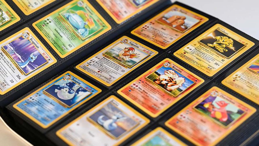A binder displaying a collection of Pokémon trading cards, including visible cards like Dragonair, Pidgeotto, Electabuzz, Arcanine, and Dragonite.