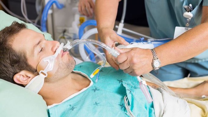 A patient on life support, with a breathing tube and medical equipment, is being attended to by a nurse. This visually represents the post's metaphor of cryptocurrencies recovering from a "deep coma."