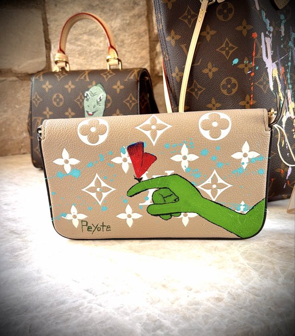 A custom-painted beige Louis Vuitton crossbody bag featuring a green pointing hand reaching toward a red butterfly and the word 'Peyote,' displayed in front of classic monogram Louis Vuitton bags.