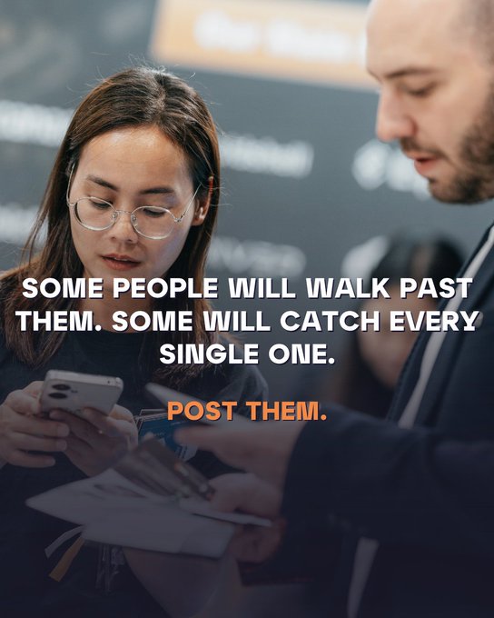 The image features a woman looking at her phone while standing next to another person who is also using their phone, possibly taking pictures or checking messages. The text above the image reads "Some people will walk past them. Some will catch every single one." This quote suggests that there might be hidden signals or Easter eggs in the venue they are visiting, and it encourages viewers to share these experiences on social media platforms like Twitter.

The image also includes a book placed near the woman's feet, which could potentially contain information about the event or location they are at. The presence of the book adds an element of curiosity and interest for those who want to learn more about the venue or its history.