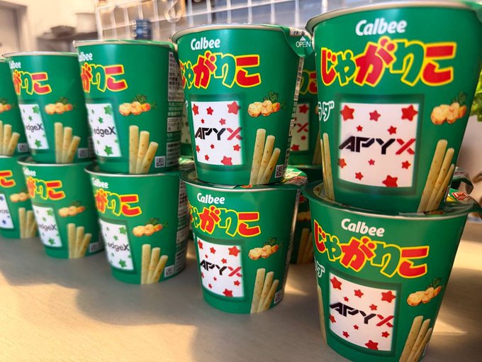 Multiple green Calbee Jagariko snack cups labeled 'APYX' stacked on a shelf.