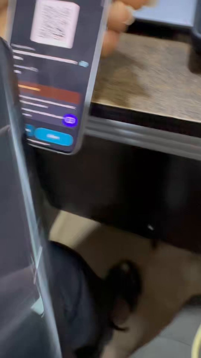 The image shows a person holding up their phone displaying a QR code or barcode. The QR code appears to be from an app called @cakewallet Moments, which is used for paying for purchases using a mobile device. This demonstrates that people have more control over their finances and can easily pay for items without the need for cash or physical cards.