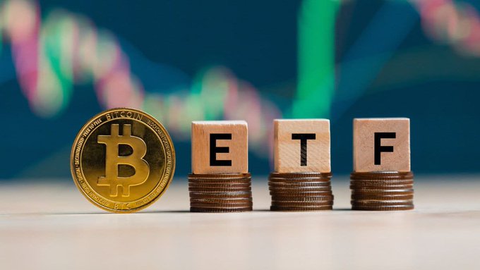 A photograph showing a gold Bitcoin coin next to wooden blocks spelling "ETF" stacked on coins, with a blurred colorful stock chart in the background.